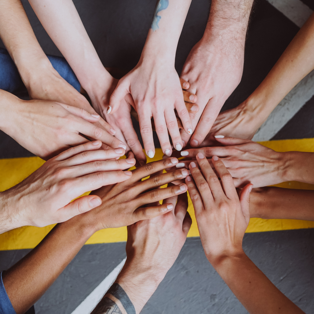 Group of hands, helping with psychosocial disability
